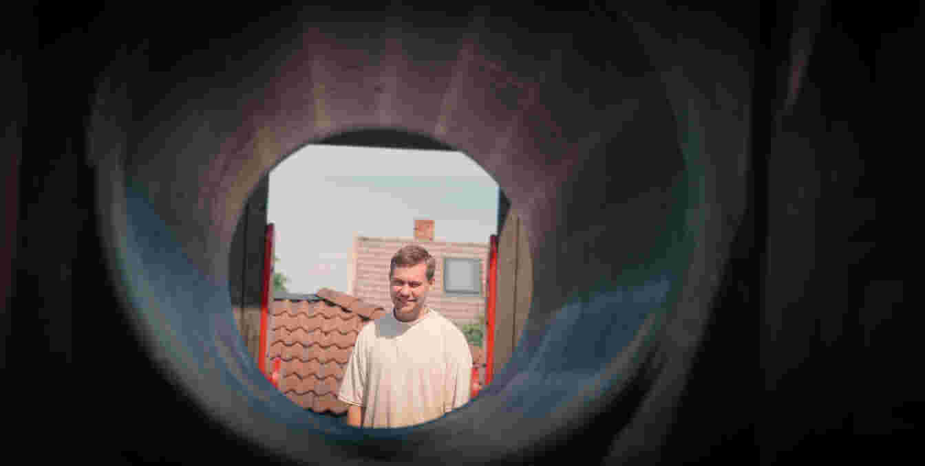 Mann ser gjennom en tunnel i et lekestativ