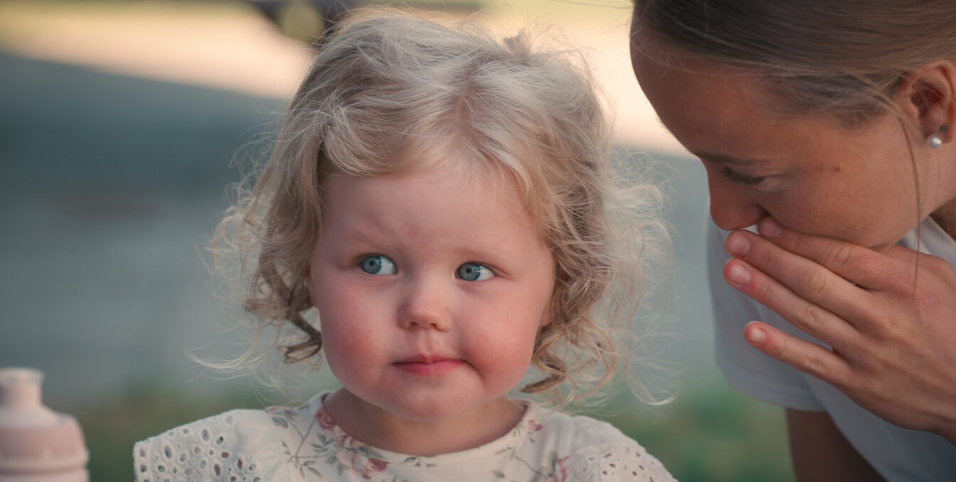 Bilde av ei jente som spiser mat sammen med en barnehageansatt