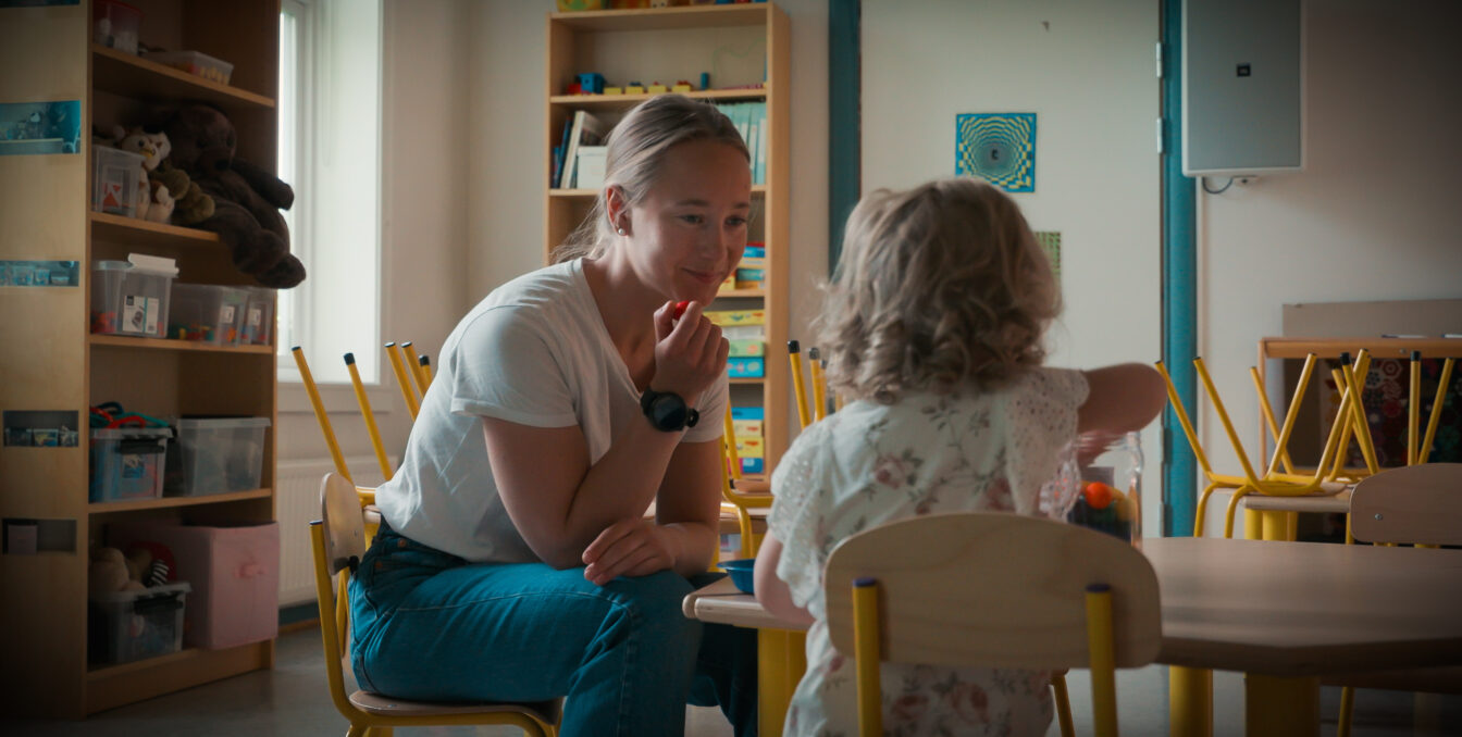 Kvinnelig barnehagelærer leker med ei lita jente