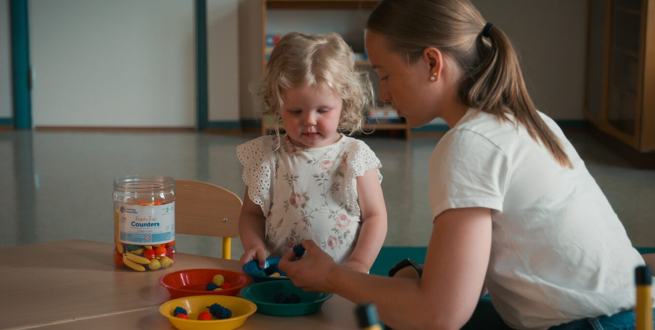 Kvinnelig barnehagelærer leker med barn
