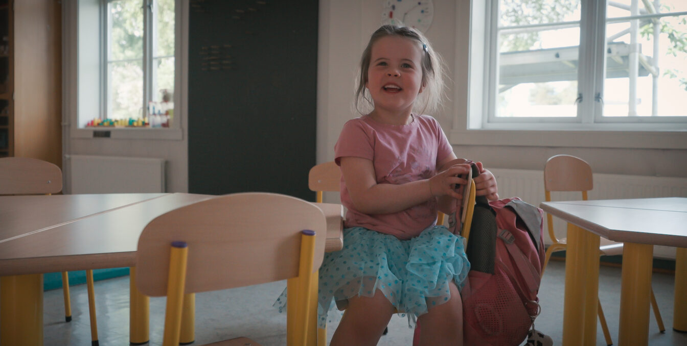 Barn sitter på en stol inne i en barnehage