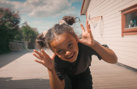 Jentebarn tøyser og smiler foran kameraet