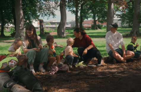 Nytt og gratis studietilbud: Ledelse i hverdagens didaktikk Fire barn og tre voksen sitter på en trestamme i en park og spiser lunsj sammen.