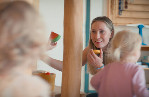 Barnehagelærer leker med to barn