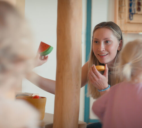 Barnehagelærer leker med to barn