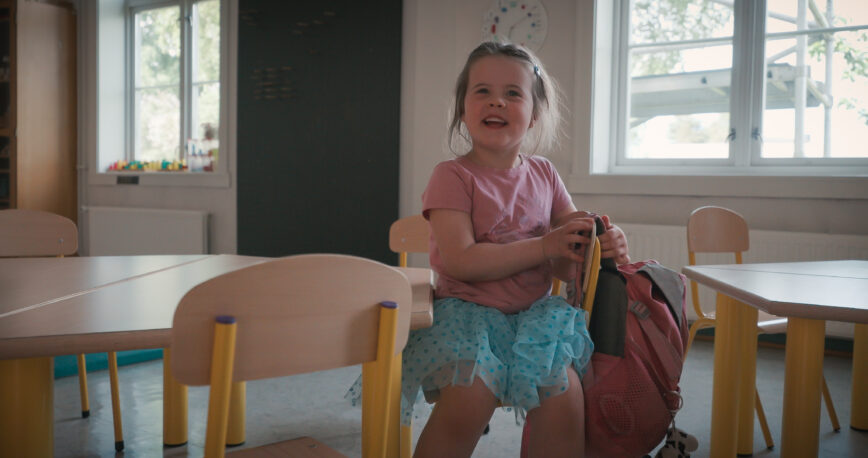 Barn sitter på en stol inne i en barnehage