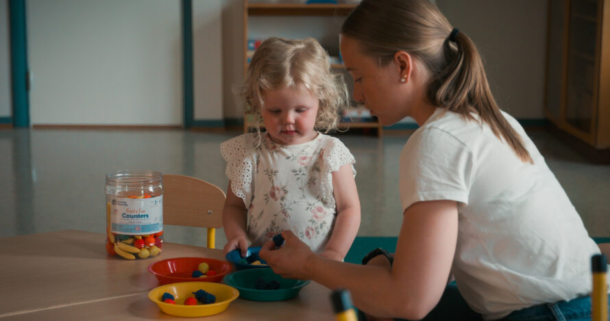 Kvinnelig barnehagelærer leker med barn