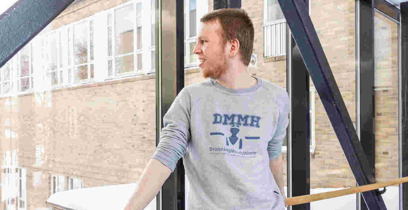 Mannlig ser ut av vindu ved et rekkverk