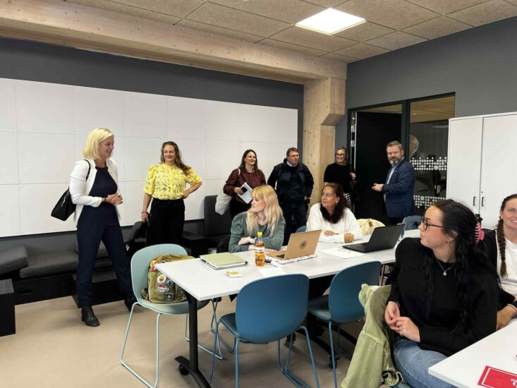 EN kvinne med sitt følge går inn i et klasserom.