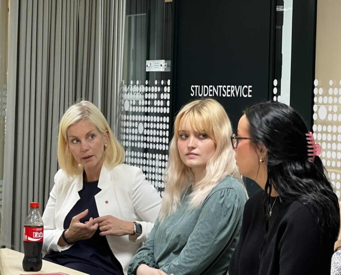 En minister snakker med to kvinner.