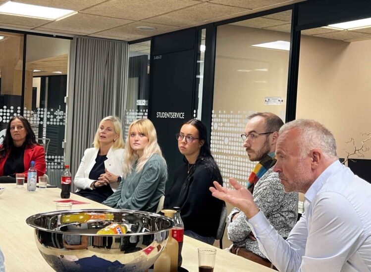 Flere mennesker sitter ved et bord.