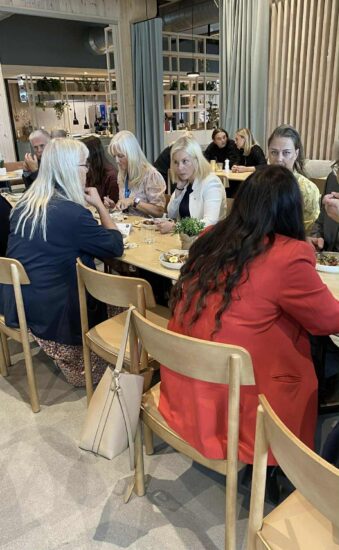 Flere personer sitter ved et bord og spiser.