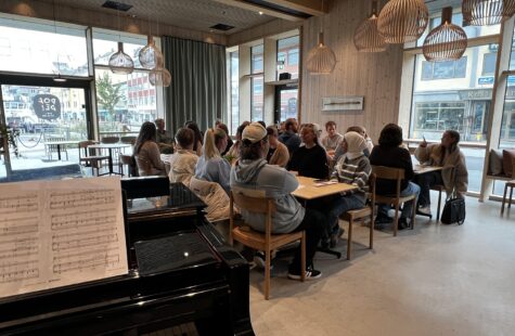Åpning av studieåret i Kristiansund Bilde av et halvt piano og studenter som sitter i et klasserom.