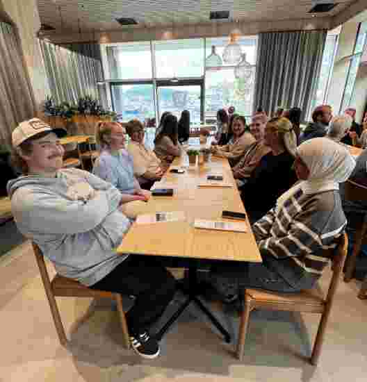 Et langbord med flere studenter rundt.