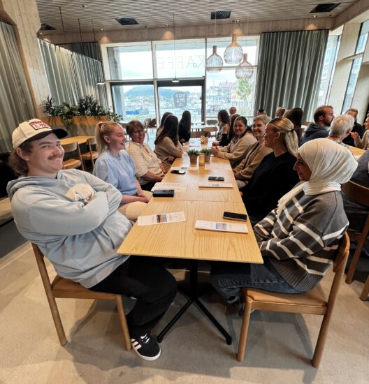 Et langbord med flere studenter rundt.