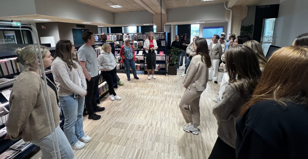 Flere studenter står i et rom og ser seg om.