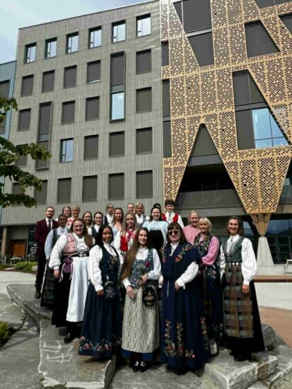 Fornøyde mennesker i pene klær står utenfor Campus Kristiansund.