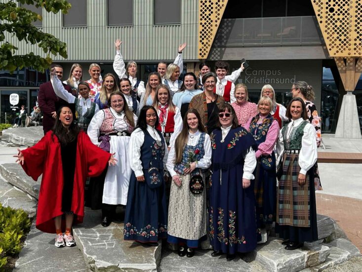 Glade studenter jubler i pene klær.