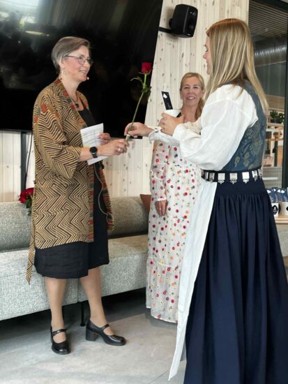 En kvinne rekker en annen kvinne hånden.