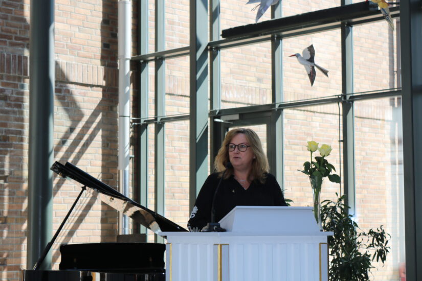 En kvinne står ved en talerstol.