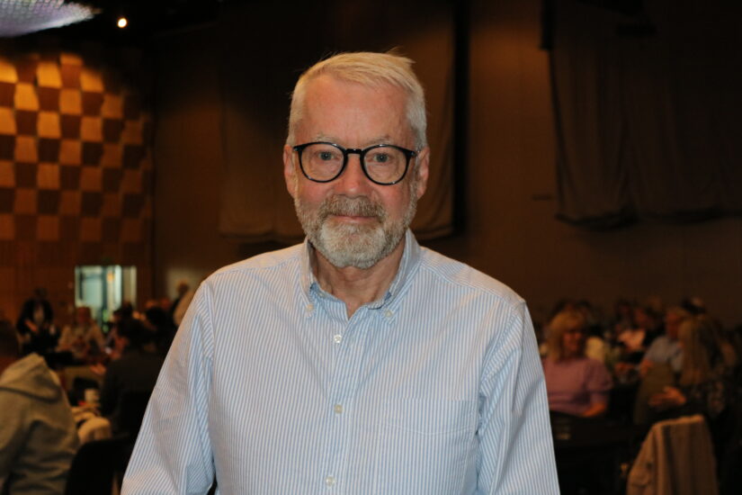 En mann står i forgrunnen av en større sal