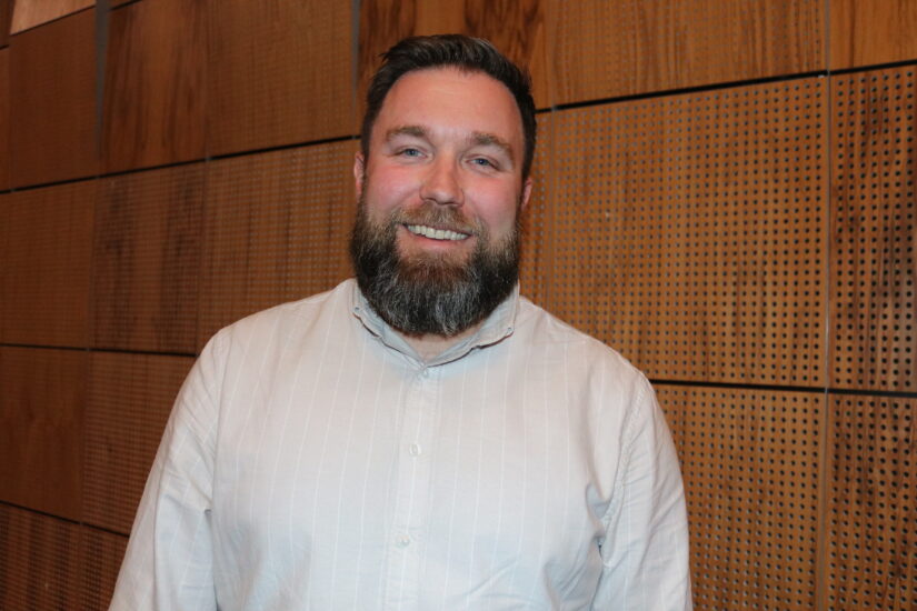 En mann står foran en vegg