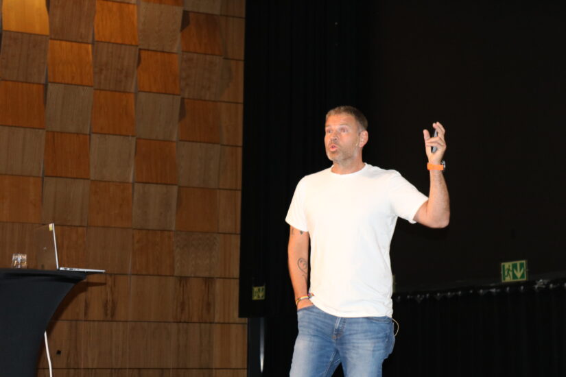 En mann står på en scene og snakker