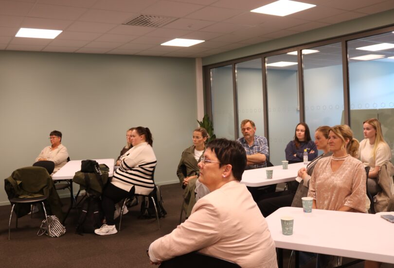 Flere folk sitter rundt noen bord.