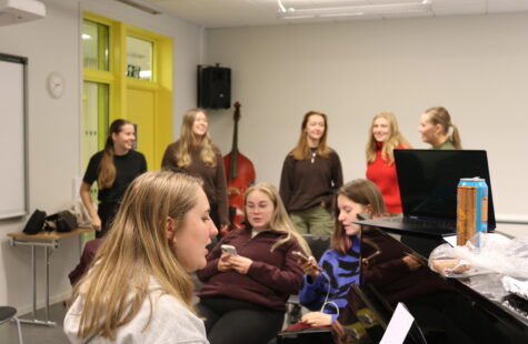 Konsert for klassetur ilde av noen studenter som øver rundt et piano