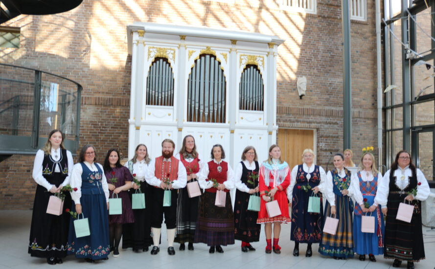 Festkledde mennesker står i en lang rekke.