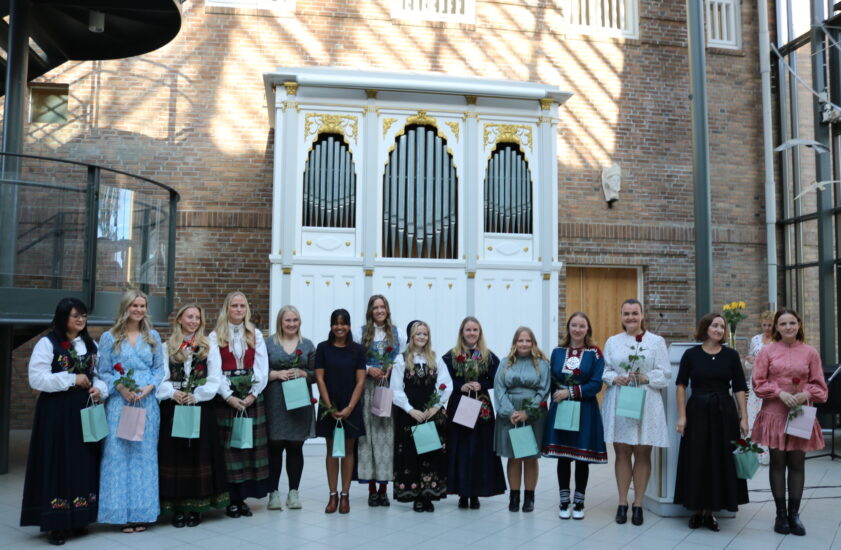 Et bilde av en gjeng unge mennesker står oppstilt, alle i pene klær.