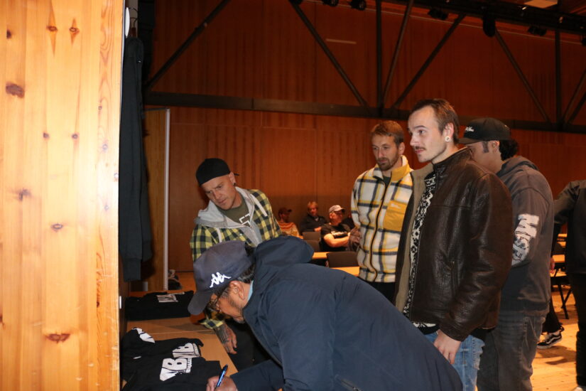 Noen menn står i kø for å få utlevert Mib-tskjorte.