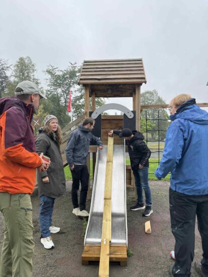 Noen setter en boks på en sklie og skal til å slippe den.