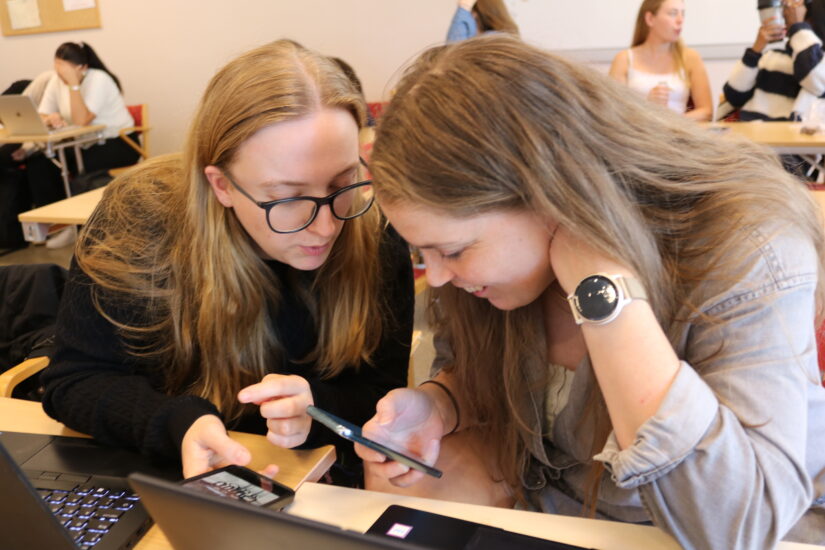 To kvinner ser på en laptop sammen,