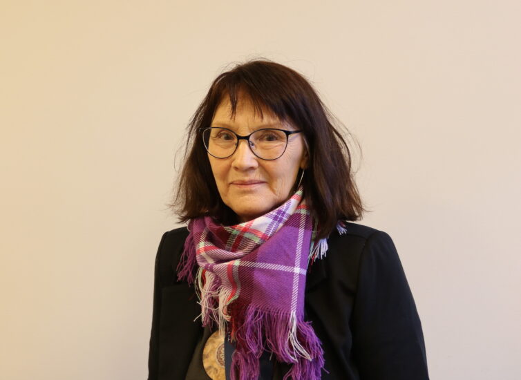 Portrett av en kvinne med et lilla skjerf.