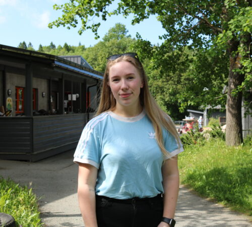 En ung kvinne står foran en barnehage.