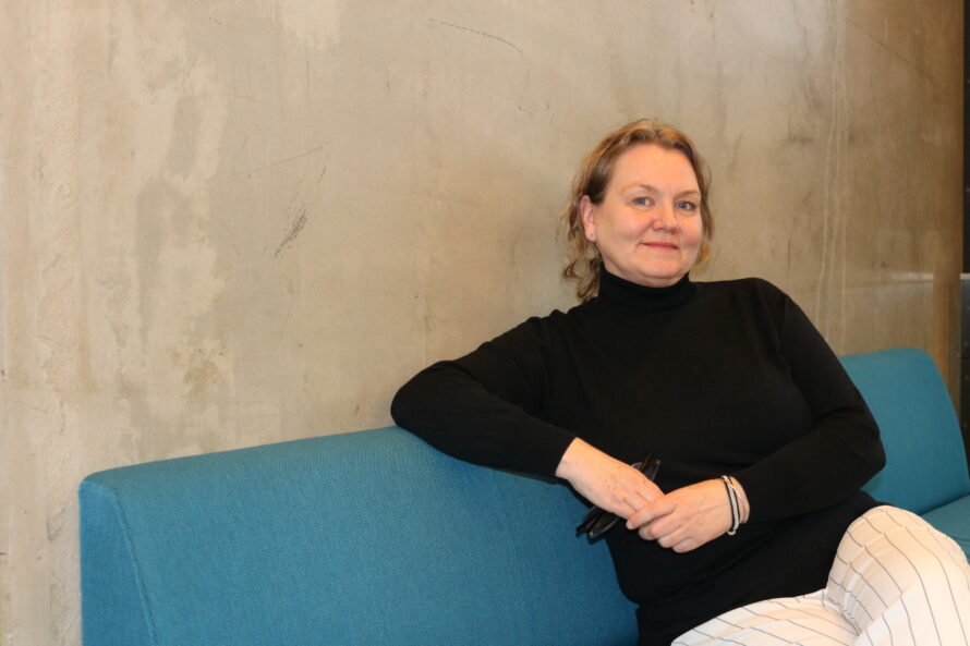 En kvinne sitter i en blå sofa.