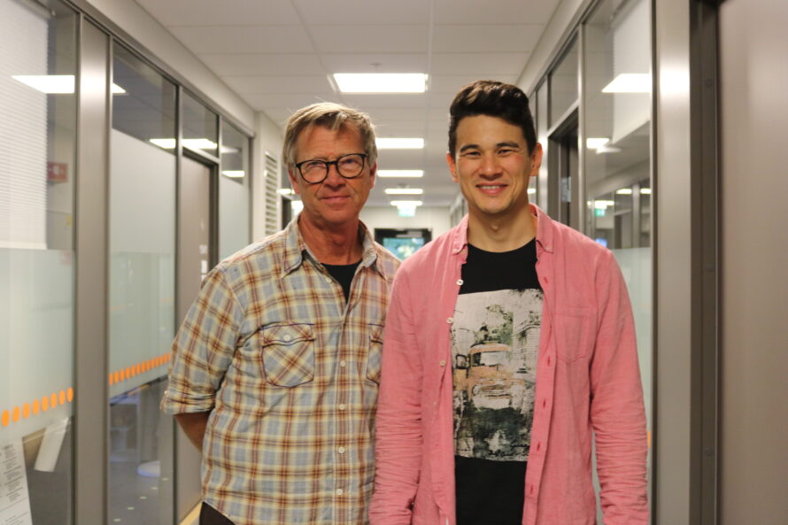 To menn står i en korridor.