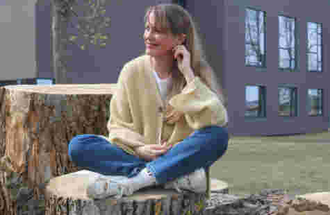 Året jeg fikk gå i barnehage har betydning for den jeg er i dag En kvinne sitter på en trestubbe.