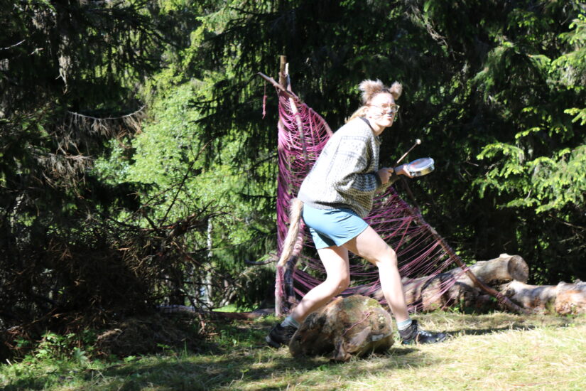 En kvinne med dyreører er ute i skogen.
