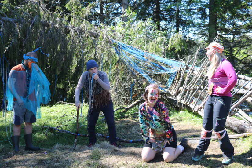 4 unge mennesker i kostymer er ute i skogen.