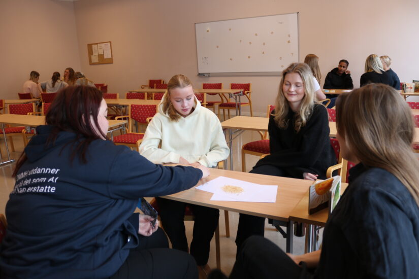 4 unge kvinner sitter rundt et bord.