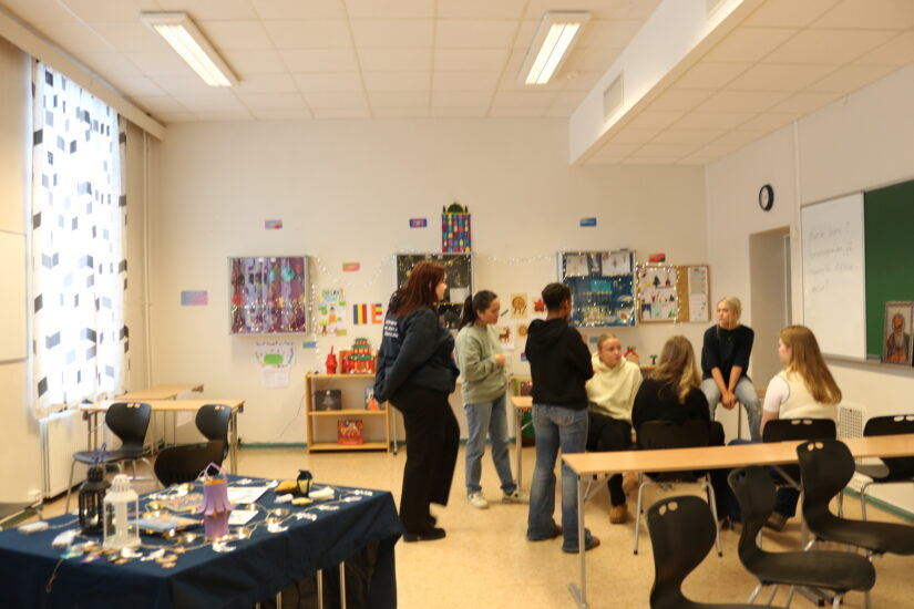 Flere mennesker står i et klasserom.