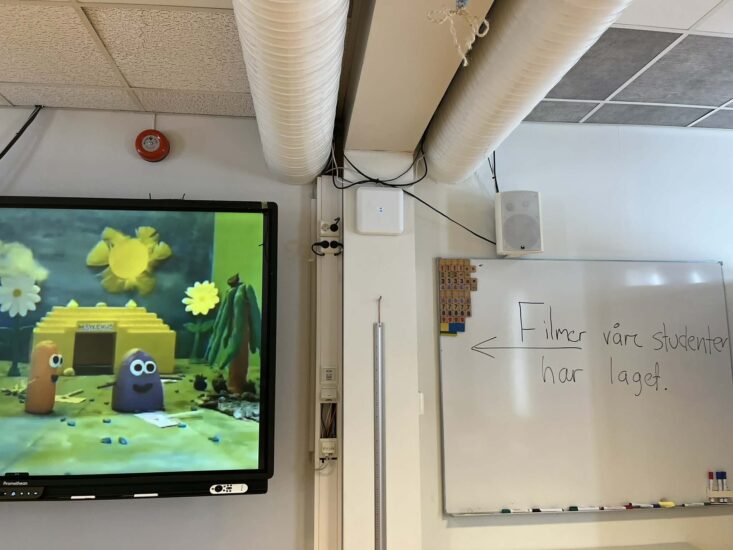 Bilde av en halv tv-skjerm og en tavle med tekst ved siden av.