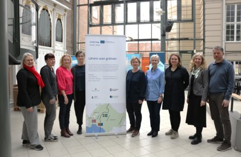 Flere folk står rundt en roll-up.