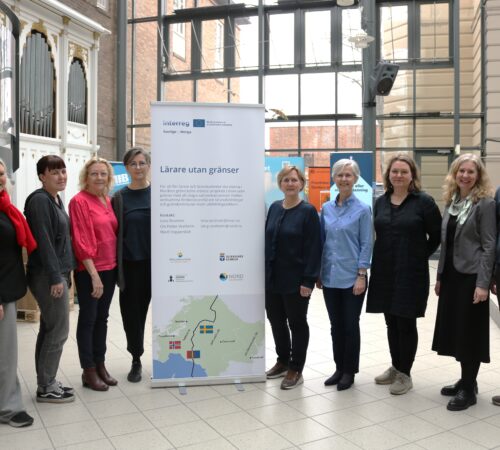 Flere folk står rundt en roll-up.