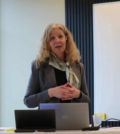 En kvinne prater til et usynlig publikum.