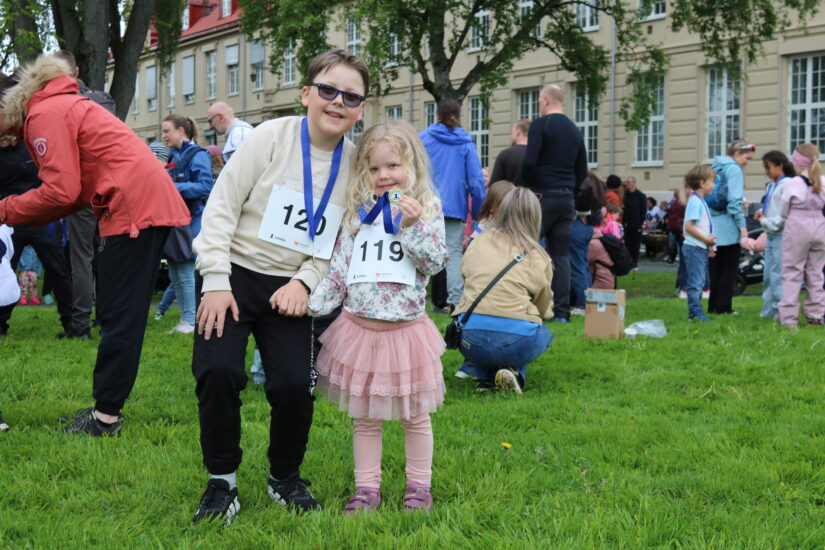 To barn smiler, de har medaljer rundt halsen.