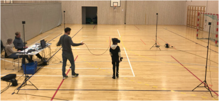 A gymnasium with a child and some adults.