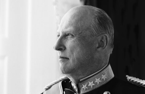 Nøye profilbilde av en eldre person i elegant militæruniform med medaljer og stjerner, ser ut mot venstre mot en lys bakgrunn.